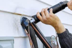 shutterstock 1713974440 Sealing,Of,Silicone,Holes,After,Installation,Of,Air,Conditioning,Pipes